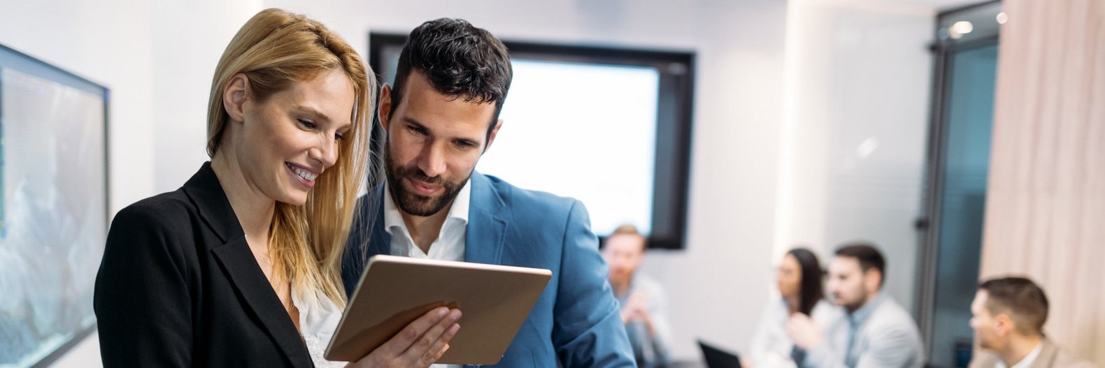 Geschäftsleute diskutieren während der Verwendung von digitalen Tablets im Büro.