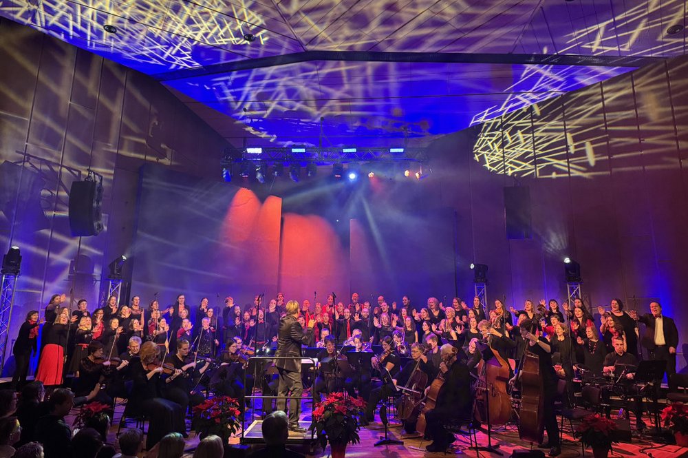 Blick auf die bunt beleuchtete Bühne mit allen Musiker*innen