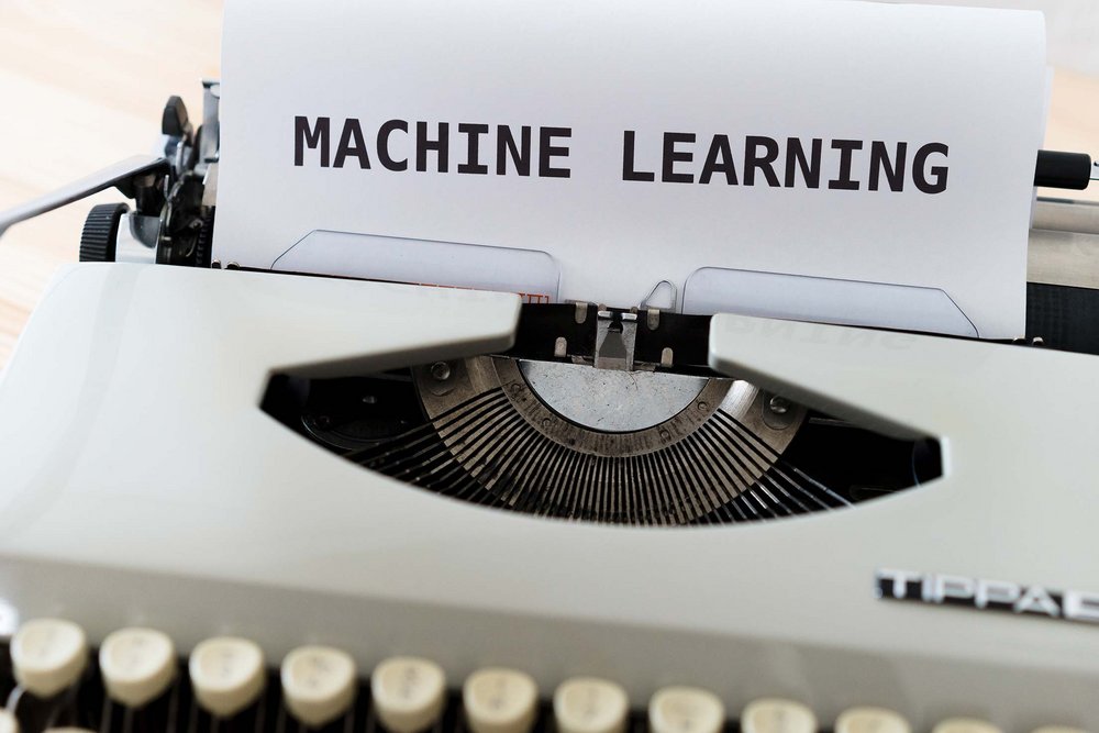 Schreibmaschine, in deren Papiereinzug ein Blatt mit der Aufschrift "Machine Learning" steckt.