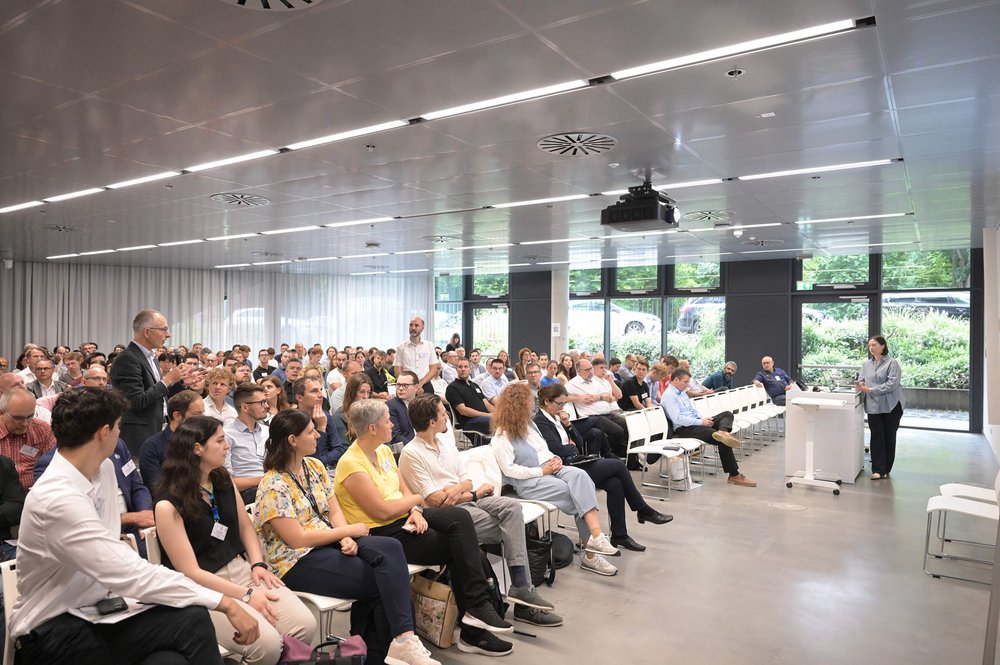 Dr. Alina Gales bei ihrem Vortrag, dem zahlreiche Teilnehmende im voll besetzten Konferenzsaal zuhören.